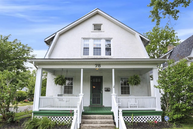 78 Griswold St, Delaware, OH 43015 - view of front of home featuring a porch, stucco siding, and a gambrel roof