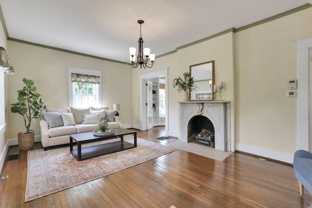 78 Griswold St, Delaware, OH 43015 - living room with a chandelier, hardwood / wood-style floors, baseboards, crown molding, and a fireplace with flush hearth