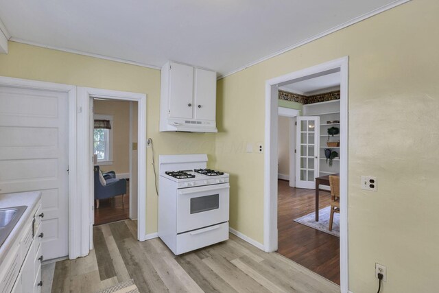 78 Griswold St, Delaware, OH 43015 - kitchen with white range with gas cooktop, under cabinet range hood, light wood-style floors, white cabinets, and crown molding