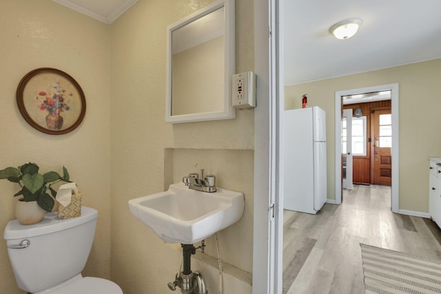 78 Griswold St, Delaware, OH 43015 - bathroom featuring wood finished floors, toilet, crown molding, and baseboards