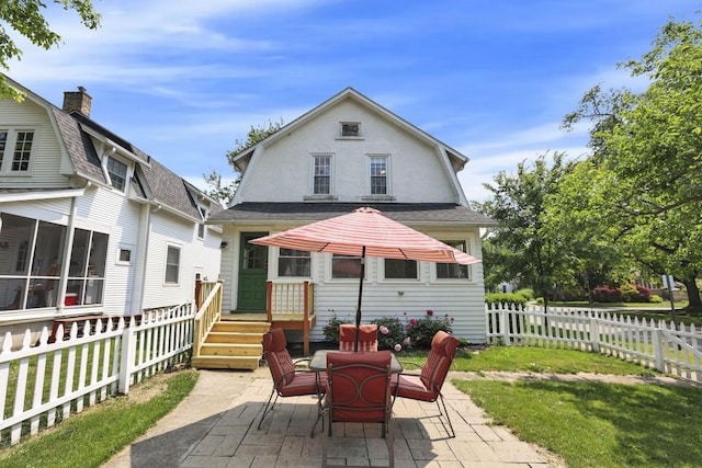 78 Griswold St, Delaware, OH 43015 - back of property with a patio area, a fenced backyard, roof with shingles, a gambrel roof, and outdoor dining area