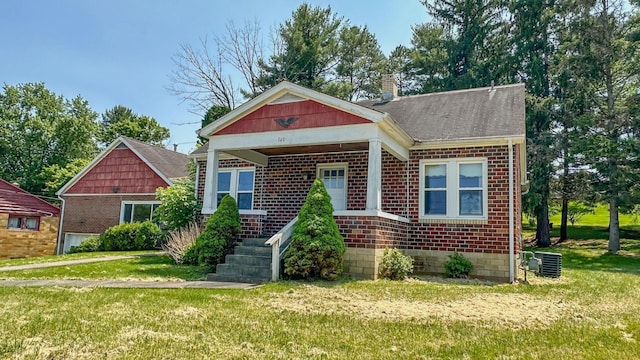 949 Mohican Ave, Logan, OH 43138 - view of front of property with a chimney, a front lawn, brick siding, and central air condition unit