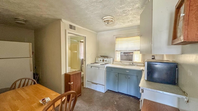 949 Mohican Ave, Logan, OH 43138 - kitchen featuring washer / clothes dryer, freestanding refrigerator, light countertops, dark colored carpet, and a textured ceiling