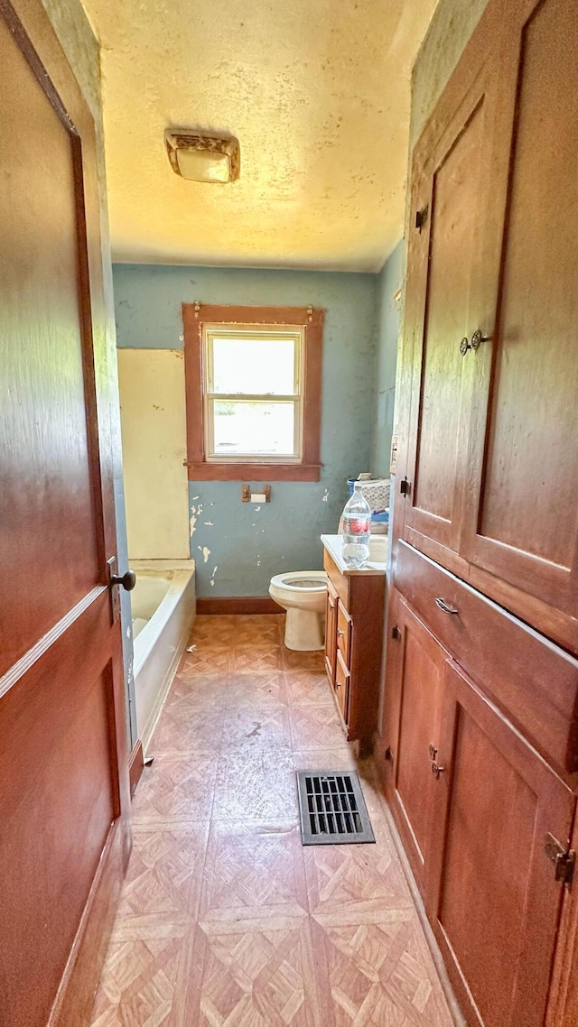 949 Mohican Ave, Logan, OH 43138 - full bathroom featuring toilet, vanity, a tub, baseboards, and a textured ceiling