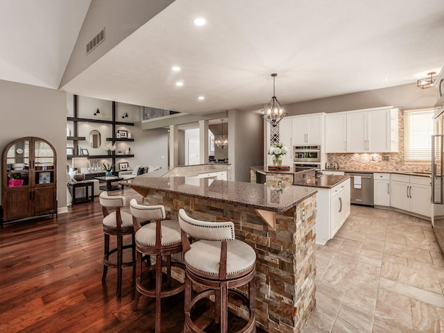 1488 Brittingham Ln, Powell, OH 43065 - kitchen with stainless steel appliances, a spacious island, a chandelier, recessed lighting, and backsplash