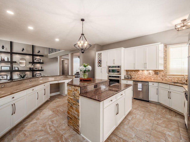1488 Brittingham Ln, Powell, OH 43065 - kitchen with appliances with stainless steel finishes, a kitchen island, decorative backsplash, light stone finish flooring, and recessed lighting