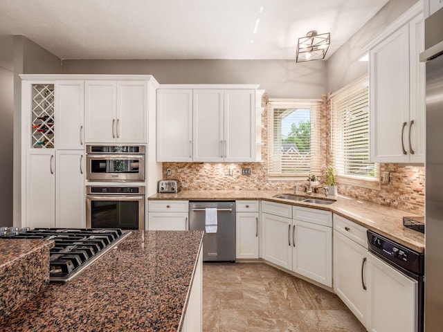 1488 Brittingham Ln, Powell, OH 43065 - kitchen with stainless steel appliances, white cabinetry, tasteful backsplash, and dark stone countertops