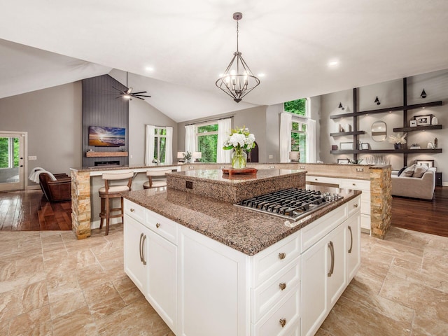 1488 Brittingham Ln, Powell, OH 43065 - kitchen featuring open floor plan, stainless steel gas cooktop, a center island, healthy amount of natural light, and lofted ceiling
