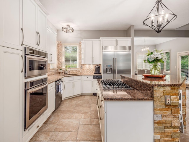 1488 Brittingham Ln, Powell, OH 43065 - kitchen with stainless steel appliances, a chandelier, a kitchen island, and white cabinets