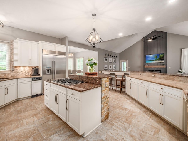 1488 Brittingham Ln, Powell, OH 43065 - kitchen featuring healthy amount of natural light, appliances with stainless steel finishes, a center island, decorative light fixtures, and vaulted ceiling