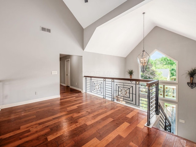 1488 Brittingham Ln, Powell, OH 43065 - empty room with wood-type flooring, high vaulted ceiling, and a chandelier