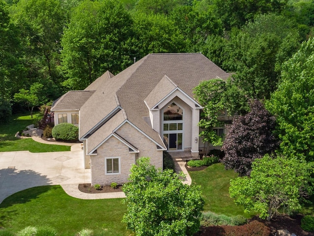 1488 Brittingham Ln, Powell, OH 43065 - view of front of home with stone siding, roof with shingles, and a front lawn