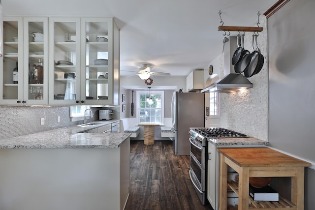 155 Aldrich Rd, Columbus, OH 43214 - kitchen with stainless steel appliances, wall chimney range hood, backsplash, light stone counters, and dark wood-type flooring