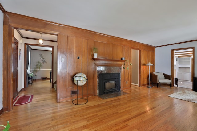 155 Aldrich Rd, Columbus, OH 43214 - unfurnished living room featuring crown molding, light wood-style floors, a high end fireplace, and wood walls