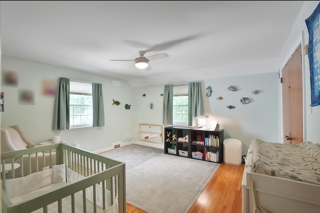 155 Aldrich Rd, Columbus, OH 43214 - bedroom with multiple windows, light wood-type flooring, ceiling fan, and a crib