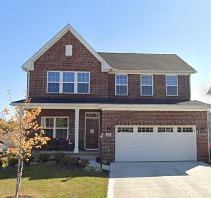 205 Arlington Dr, Pickerington, OH 43147 - view of front of property featuring driveway, a front yard, a garage, and brick siding