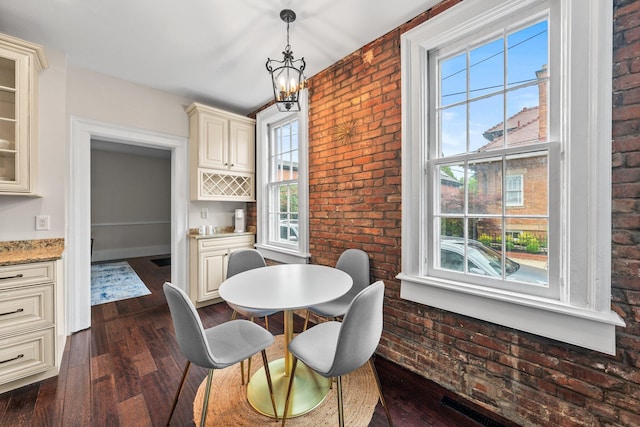 145 E Sycamore St, Columbus, OH 43206 - dining area with brick wall and dark wood-style flooring