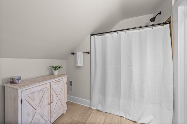 145 E Sycamore St, Columbus, OH 43206 - full bath featuring vaulted ceiling, baseboards, and a shower with curtain