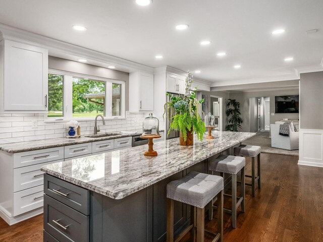 1360 Clubview Blvd S, Columbus, OH 43235 - kitchen featuring crown molding, a sink, light stone countertops, white cabinets, and backsplash