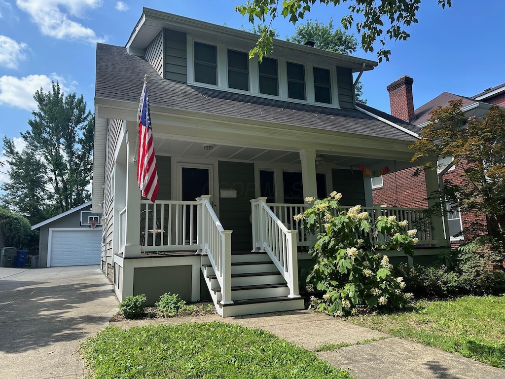 135 Richards Rd, Columbus, OH 43214 - bungalow-style home with covered porch, an outdoor structure, roof with shingles, and a garage