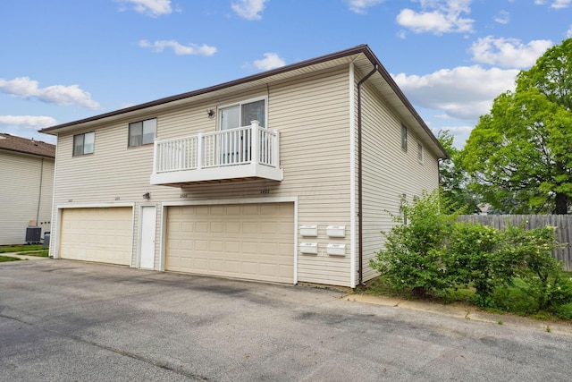 2422 Briers Dr Unit D, Columbus, OH 43209 - back of property with a balcony, an attached garage, central AC unit, and driveway