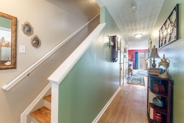 4655 Athalia Dr Unit 20B, Columbus, OH 43228 - hall featuring a textured ceiling, wood finished floors, stairs, and baseboards