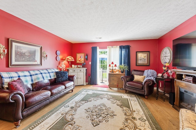 4655 Athalia Dr Unit 20B, Columbus, OH 43228 - living area with wood finished floors, a textured ceiling, and a glass covered fireplace