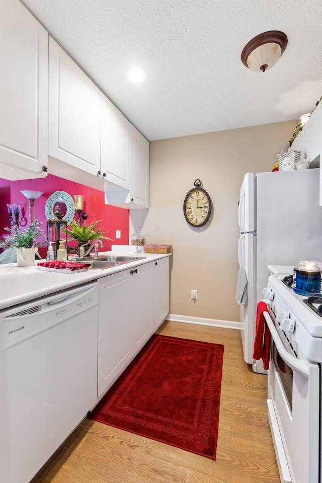 4655 Athalia Dr Unit 20B, Columbus, OH 43228 - kitchen with white appliances, white cabinetry, baseboards, a textured ceiling, and light countertops