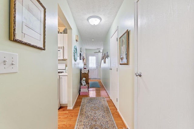 4714 Athalia Dr Unit 26B, Columbus, OH 43228 - hall featuring light wood-type flooring, a textured ceiling, and baseboards