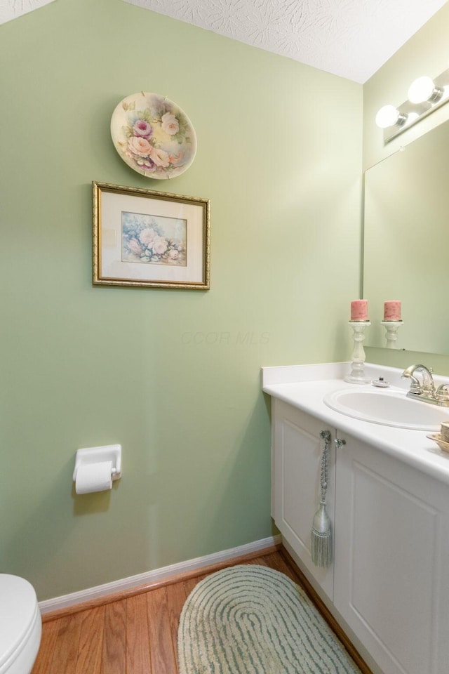 4714 Athalia Dr Unit 26B, Columbus, OH 43228 - bathroom featuring vanity, toilet, baseboards, and wood finished floors