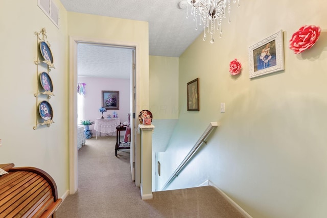 4714 Athalia Dr Unit 26B, Columbus, OH 43228 - hallway with an upstairs landing, carpet flooring, a chandelier, and a textured ceiling