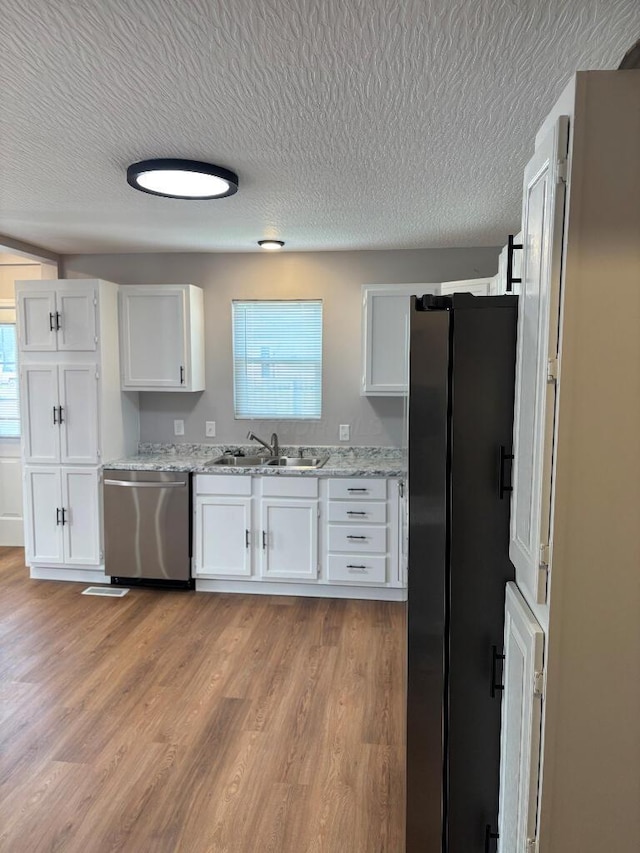 418 Clinton St, Circleville, OH 43113 - kitchen featuring stainless steel appliances, white cabinets, a textured ceiling, healthy amount of natural light, and light wood-style floors