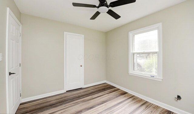 2474 Mecca Rd, Columbus, OH 43224 - unfurnished bedroom with wood finished floors, baseboards, and a ceiling fan