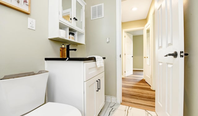 2474 Mecca Rd, Columbus, OH 43224 - half bath featuring toilet, baseboards, recessed lighting, marble finish flooring, and vanity