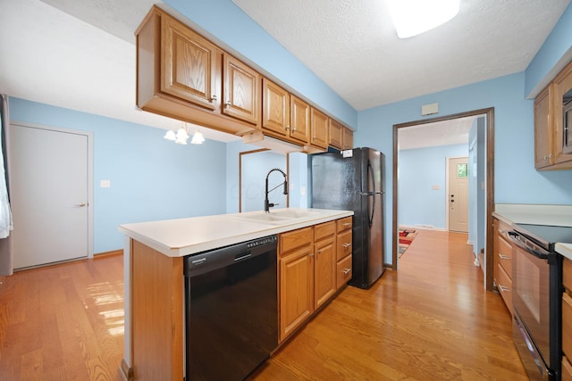 5770 Linworth Rd, Columbus, OH 43235 - kitchen with black appliances, a sink, light wood-type flooring, light countertops, and a textured ceiling
