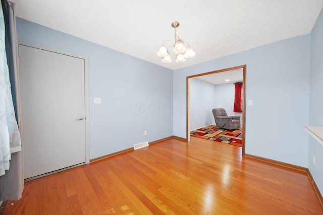 5770 Linworth Rd, Columbus, OH 43235 - unfurnished dining area with a chandelier, wood finished floors, and baseboards