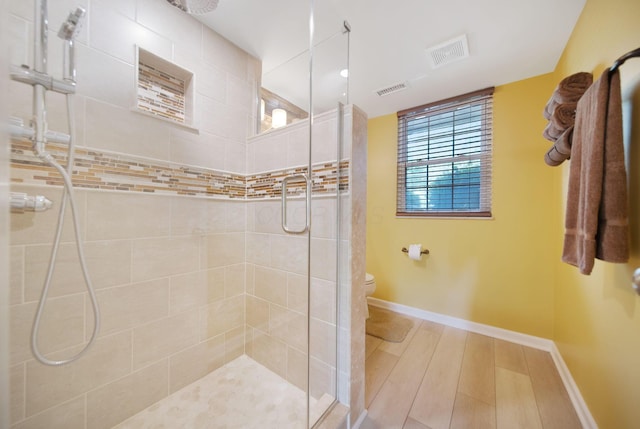 5770 Linworth Rd, Columbus, OH 43235 - full bathroom with tiled shower, toilet, baseboards, and wood finished floors