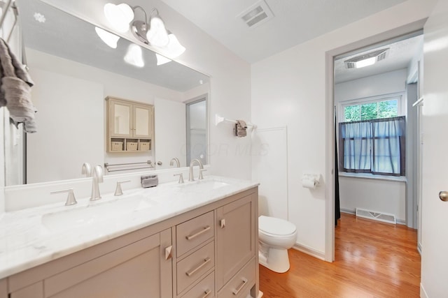 5770 Linworth Rd, Columbus, OH 43235 - bathroom with wood finished floors, double vanity, toilet, and baseboards