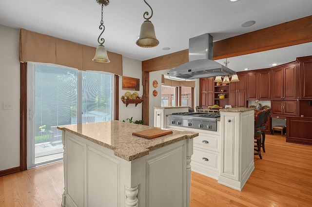 1059 Circle On The Grn, Columbus, OH 43235 - kitchen with a center island, island exhaust hood, light wood-style flooring, and stainless steel gas stovetop
