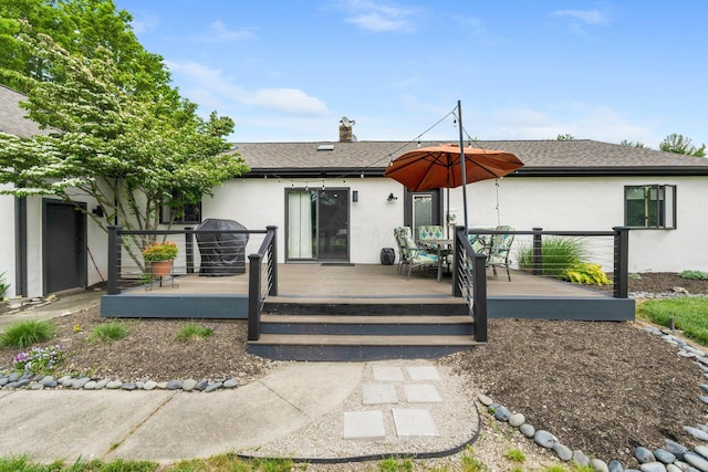3515 Babbitt Rd, Blacklick, OH 43004 - back of property with stucco siding, a wooden deck, outdoor dining area, and a shingled roof