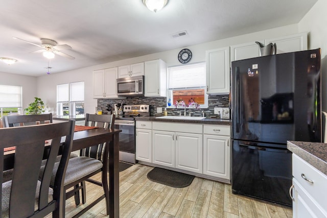 3009 Hiawatha St, Columbus, OH 43224 - kitchen with appliances with stainless steel finishes, a sink, dark countertops, and backsplash