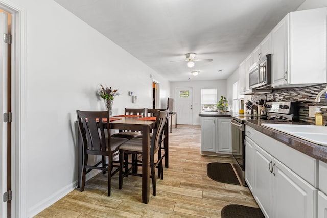 3009 Hiawatha St, Columbus, OH 43224 - kitchen featuring stainless steel appliances, ceiling fan, light wood finished floors, and white cabinets