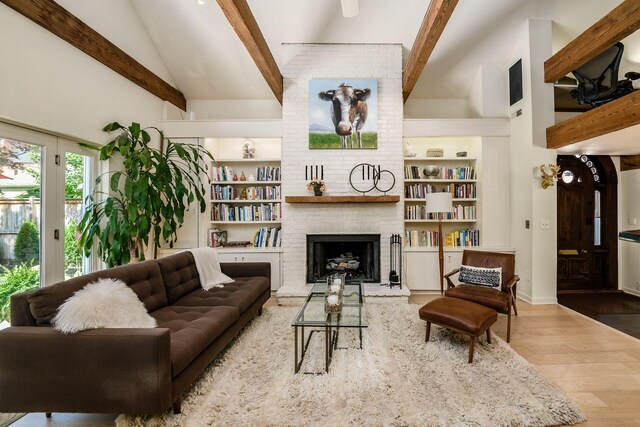 584 Franklin Ave, Columbus, OH 43215 - living room with beamed ceiling, wood finished floors, a fireplace, high vaulted ceiling, and built in shelves