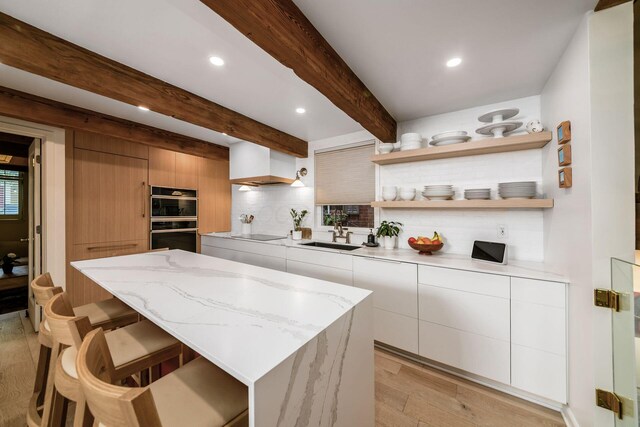584 Franklin Ave, Columbus, OH 43215 - kitchen with modern cabinets, custom exhaust hood, open shelves, black appliances, and beamed ceiling
