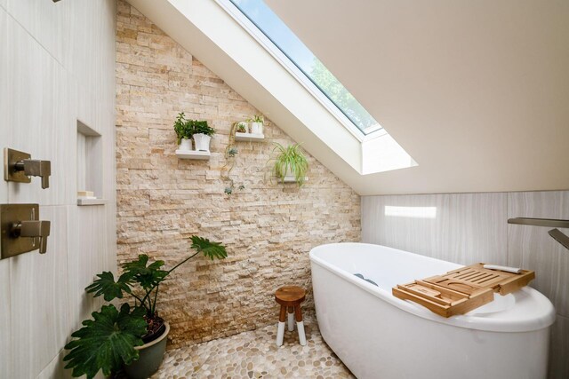 584 Franklin Ave, Columbus, OH 43215 - bathroom featuring a skylight, lofted ceiling, and a soaking tub
