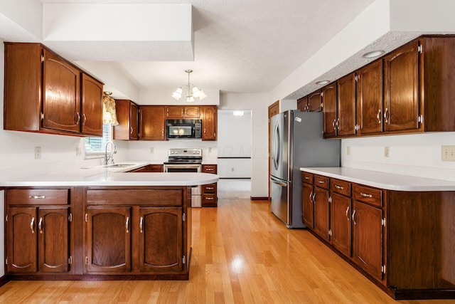 13582 Capetown Ave, Pickerington, OH 43147 - kitchen featuring appliances with stainless steel finishes, light wood-type flooring, a chandelier, a peninsula, and light countertops
