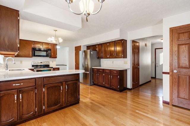 13582 Capetown Ave, Pickerington, OH 43147 - kitchen with stainless steel appliances, a chandelier, light wood-style flooring, and light countertops