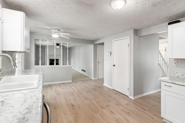 6541 Skywae Dr, Columbus, OH 43229 - kitchen featuring a sink, ceiling fan, white cabinetry, light wood-style flooring, and a textured ceiling