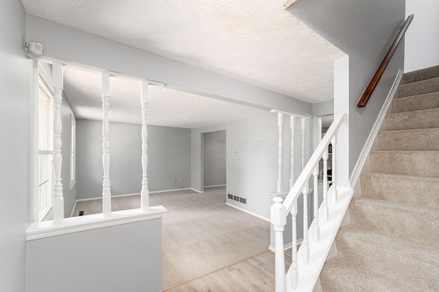 6541 Skywae Dr, Columbus, OH 43229 - staircase featuring wood finished floors, a textured ceiling, carpet flooring, and baseboards