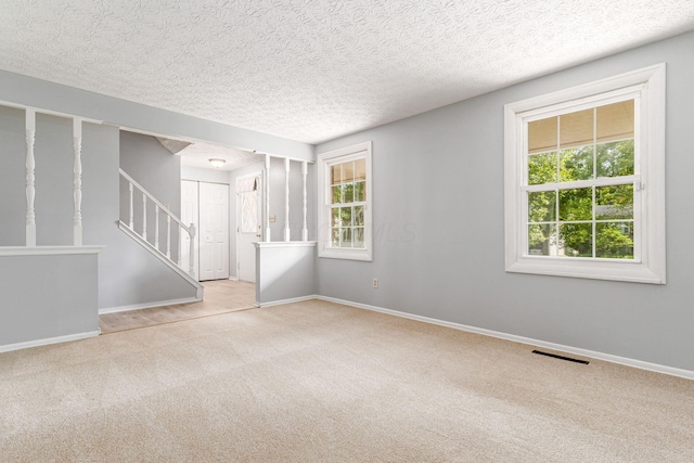 6541 Skywae Dr, Columbus, OH 43229 - carpeted empty room with plenty of natural light, baseboards, stairway, and a textured ceiling